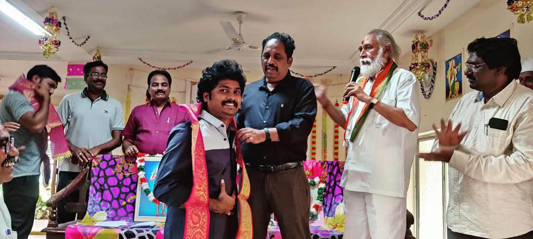 Un edificio con una puerta roja y un árbol frente a él